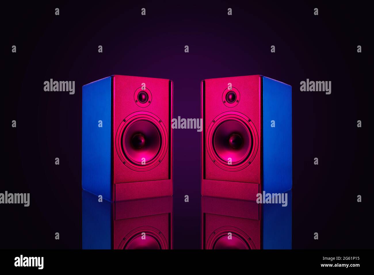 Due altoparlanti stereo color neon su sfondo scuro con riflessione.Audio altoparlanti alti, primo piano Foto Stock