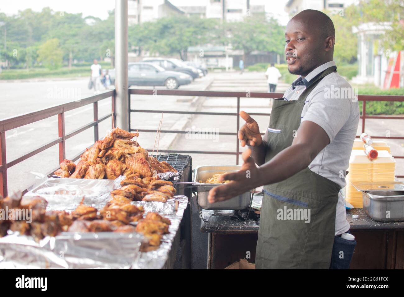 uomo africano che vende pollo alla griglia Foto Stock