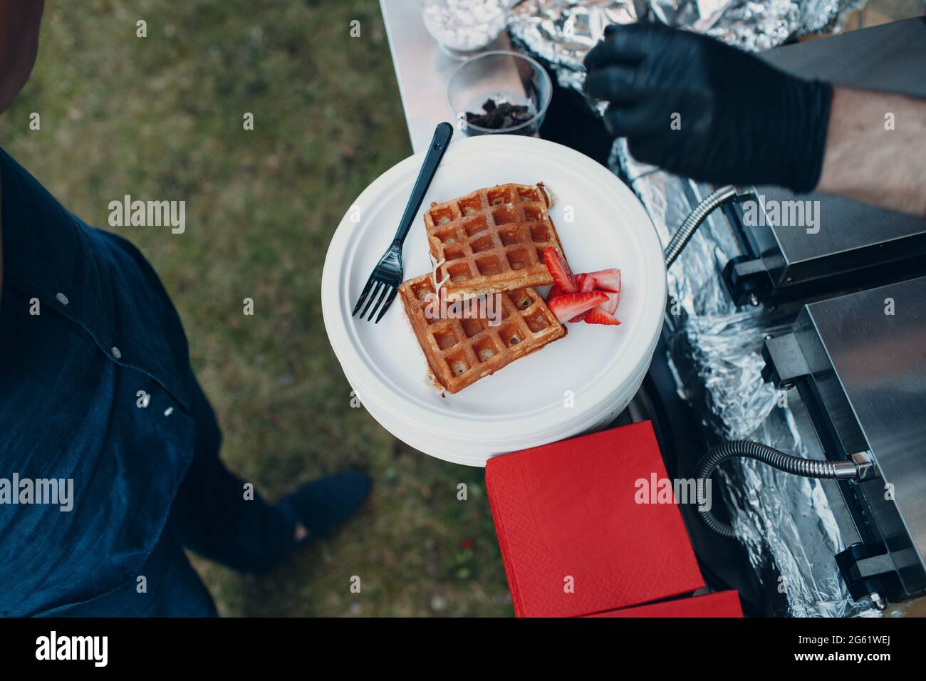 waffle olandesi su un piatto con fragole a una festa all'aperto. Foto Stock