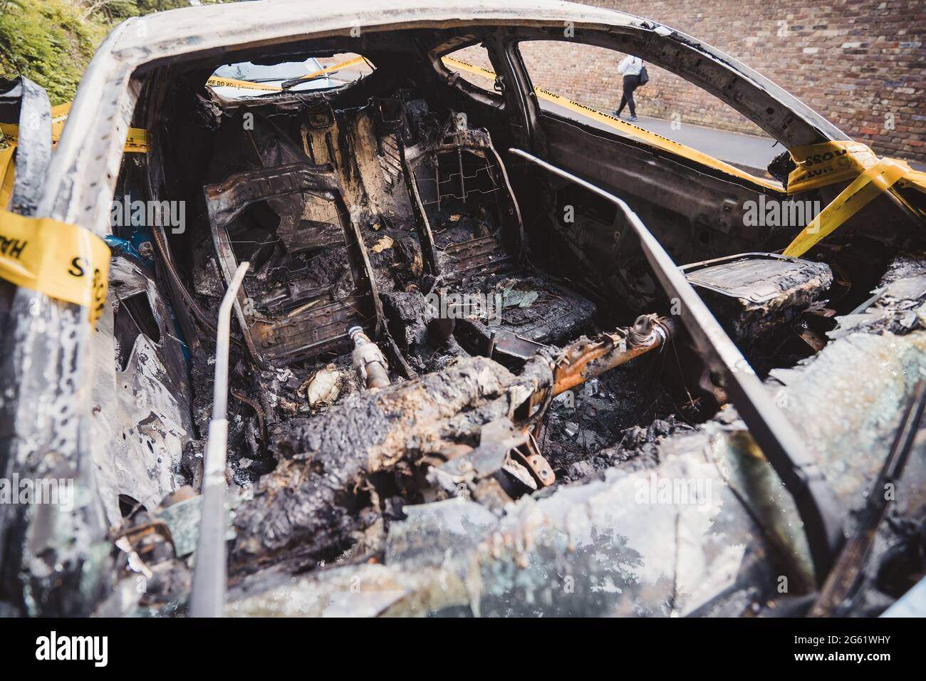 Londra | UK - 2021.06.12: Interno di un abbandonato, rubato bruciato fuori auto blu parcheggiata sul marciapiede spotб legato con giallo non attraversare striscia Foto Stock