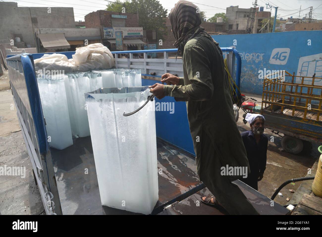 Lahore, Pakistan. 01 luglio 2021. I fornitori pakistani stanno caricando blocchi di ghiaccio nel suo veicolo caricatore dalla fabbrica di ghiaccio all'area di China Scheme per fornire diverse bancarelle, in quanto la richiesta di ghiaccio è aumentata a causa dell'alta temperatura di 43 gradi Celsius a Lahore. (Foto di Rana Sajid Hussain/Pacific Press/Sipa USA) Credit: Sipa USA/Alamy Live News Foto Stock