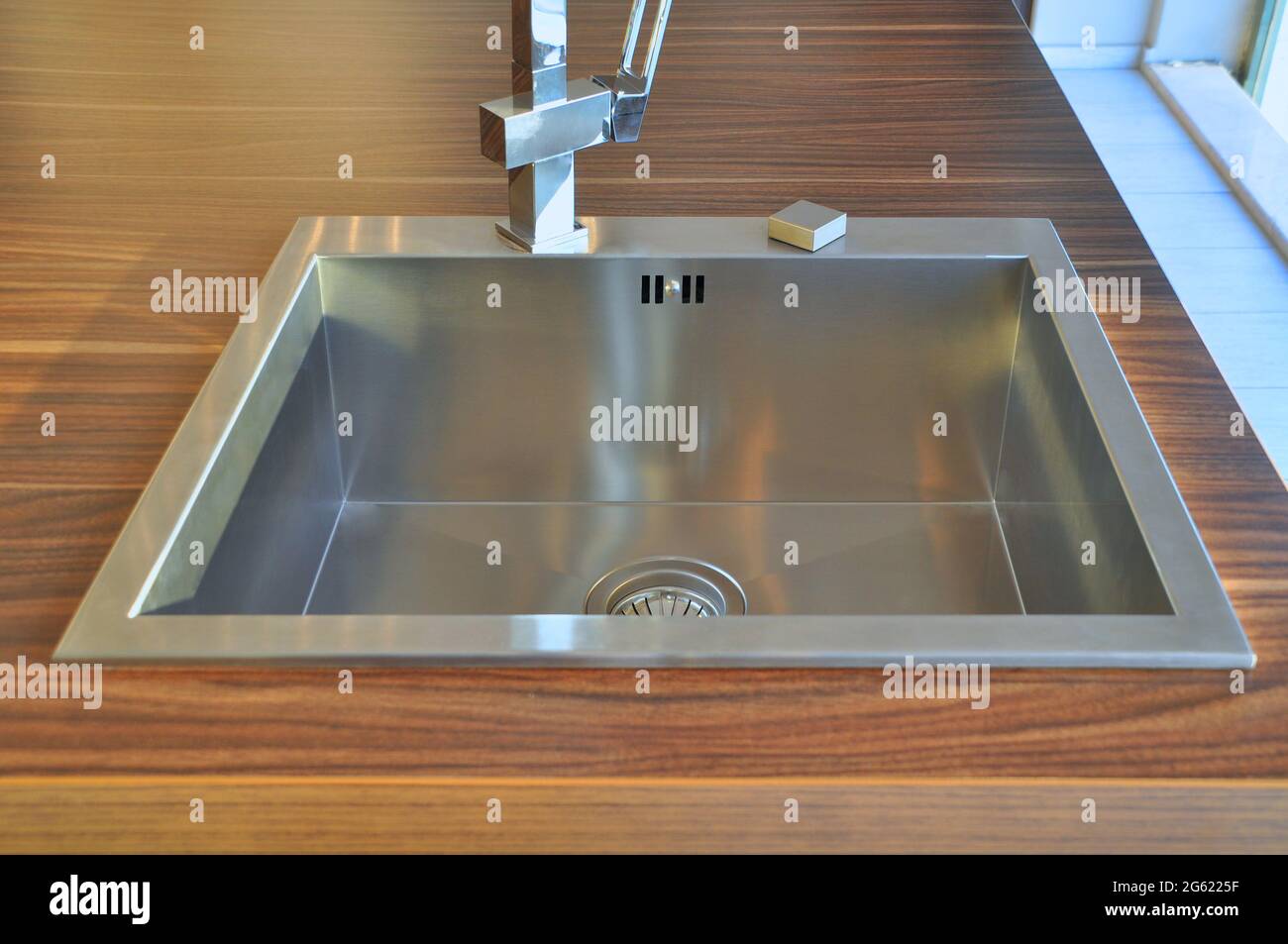 Interno di lussuosa cucina moderna e lavandino, rubinetto e scarico in acciaio inossidabile Foto Stock