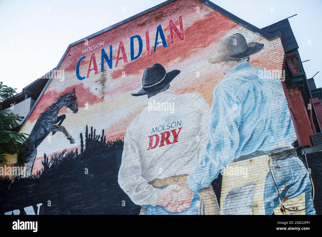 Toronto Canada,Church Street,building,wall mural,Molson Coors Brewing Company,Canadian Company,birreria,ad,targeted,cowboy,men,holding hand,hands,gay frie Foto Stock