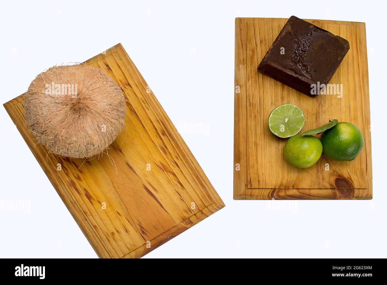 Panela di canna da zucchero, limoni e cocco su una tavola di legno su uno sfondo bianco. Limongrass e acqua di cocco sono bevande tropicali dai Caraibi Foto Stock