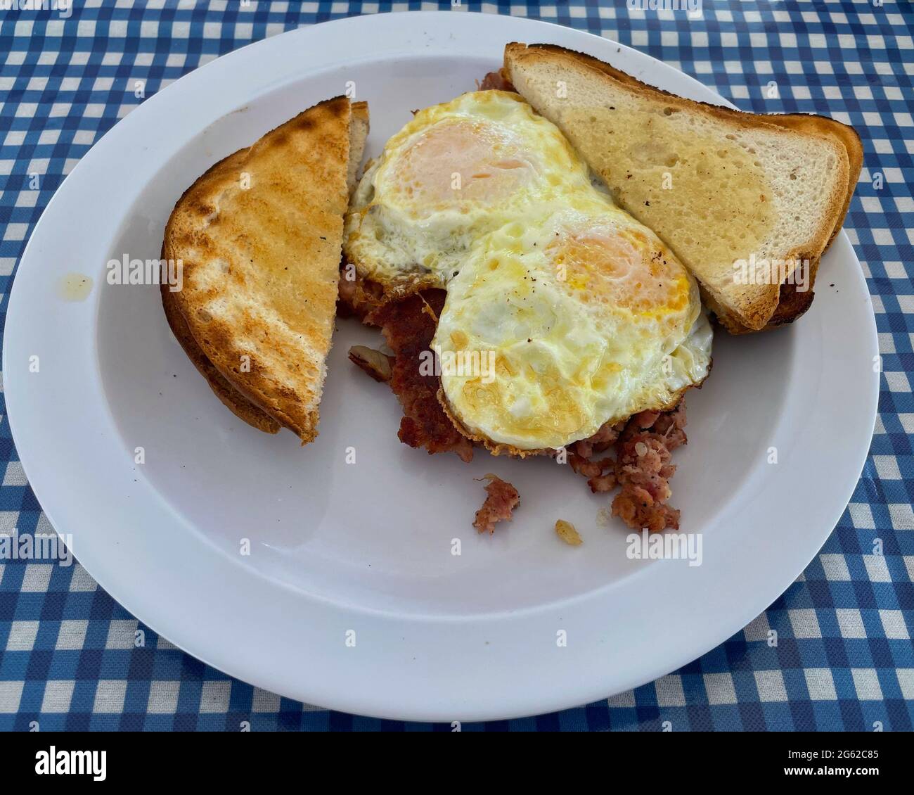 La colazione è composta da due uova su un terreno medio, oltre a patate di manzo e pane tostato. Foto Stock