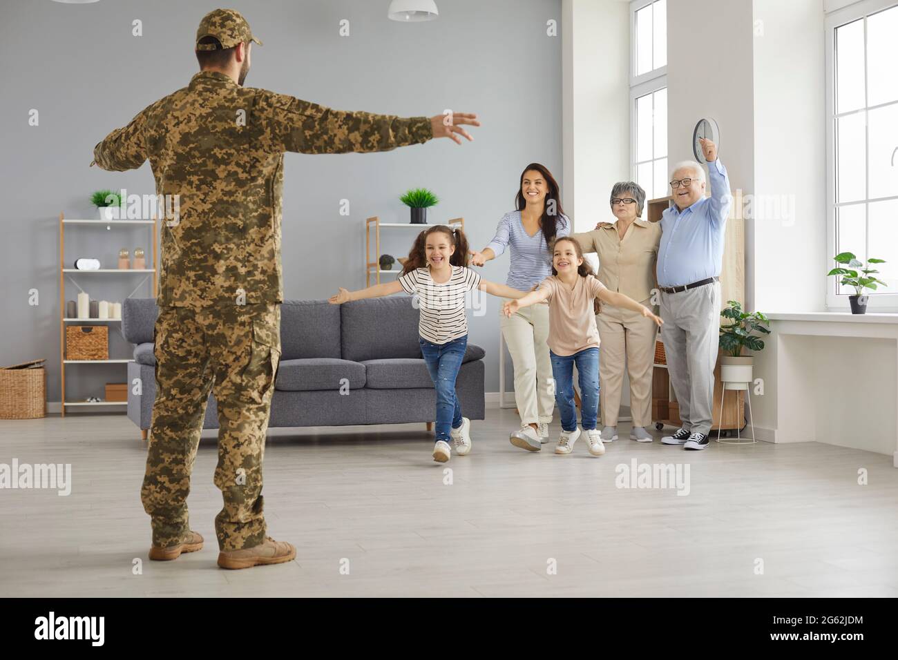 Bambini, moglie e genitori felici di vedere soldato che è tornato a casa dal servizio militare Foto Stock