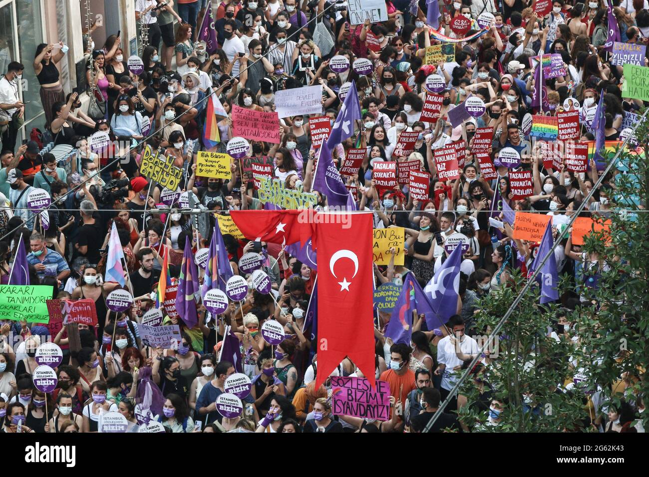 Folla di manifestanti visti su Istiklal Street cantando slogan con bandiere, striscioni e cartelli, durante la dimostrazione. Il ritiro formale della Turchia dalla Convenzione di Istanbul dal 1° luglio 2021 è stato protestato a Istanbul. C'è stata una lotta tra la polizia e gli attivisti che si sono rifiutati di permettere ai manifestanti che volevano marciare su Istiklal Street. La Convenzione di Istanbul, firmata da 45 paesi e dall'Unione europea, richiede la prevenzione di ogni tipo di violenza contro le donne, la protezione delle vittime di violenza e la punizione dei criminali. Foto Stock