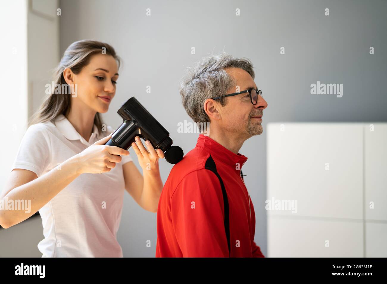 Massaggio Gun spalle terapia di recupero usando la macchina Foto Stock