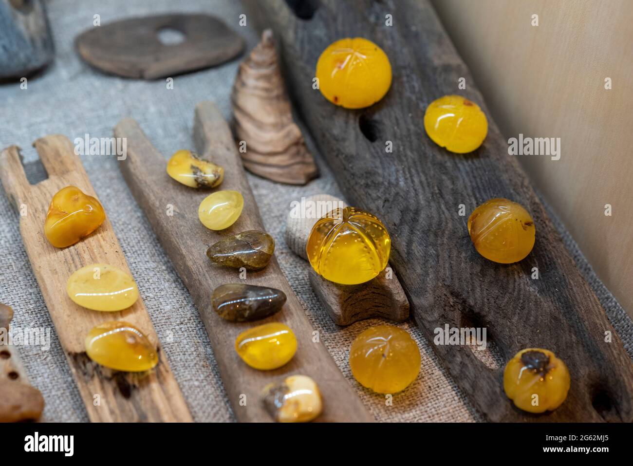 Kloster, Germania. 26 Giugno 2021. Le pietre color ambra tagliate si trovano in un display. Il proprietario della bottega d'ambra, Henry Engels, ha trovato ogni singola pietra sulla spiaggia dell'isola di Hiddensee. Ha raccolto l'oro del mare fin dalla sua infanzia. Da 20 anni lo utilizza per realizzare oggetti d'arte come orecchini e collane. Li vende ai turisti nel suo laboratorio d'ambra a Kloster. Credit: Stefano Nosini/dpa-Zentralbild/ZB/dpa/Alamy Live News Foto Stock