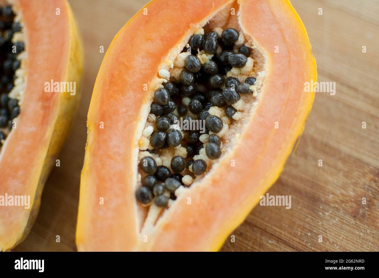 Frutta fresca di papaia matura biologica tagliata a metà su tavola di legno. Frutta esotica, concetto di alimentazione sana Foto Stock