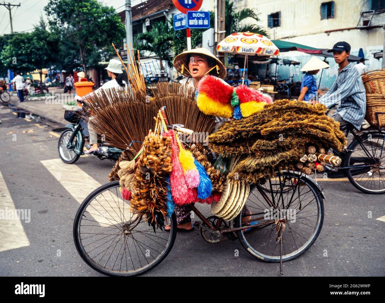 Falegname di strada che vende spazzole da una bicicletta, Saigon, ho Chi Minh città, Vietnam Foto Stock