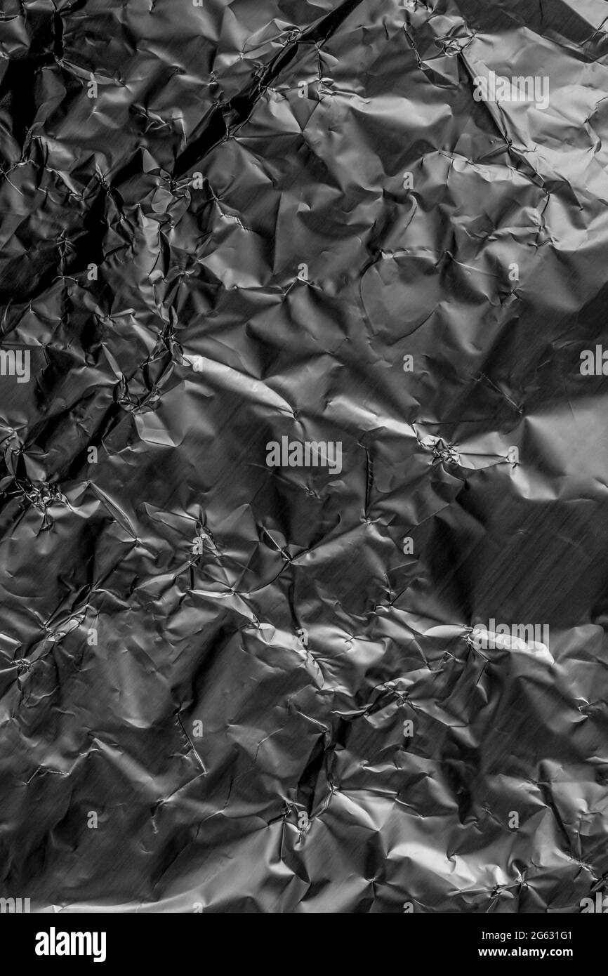 Foglio metallico in alluminio grinzito. Grunge astratto dettagliato sfondo grigio scuro Foto Stock