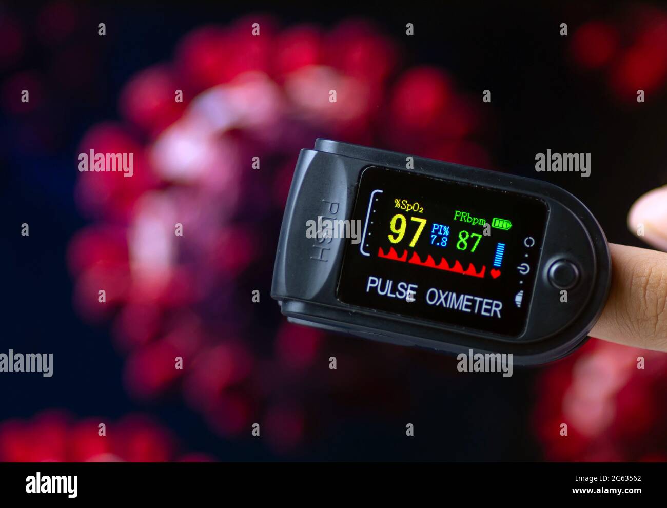 Ossimetro in un dito per il controllo della saturazione di ossigeno nel  sangue e nella frequenza cardiaca, con illustrazione di Covid-19 sfocata, a  fuoco basso Foto stock - Alamy