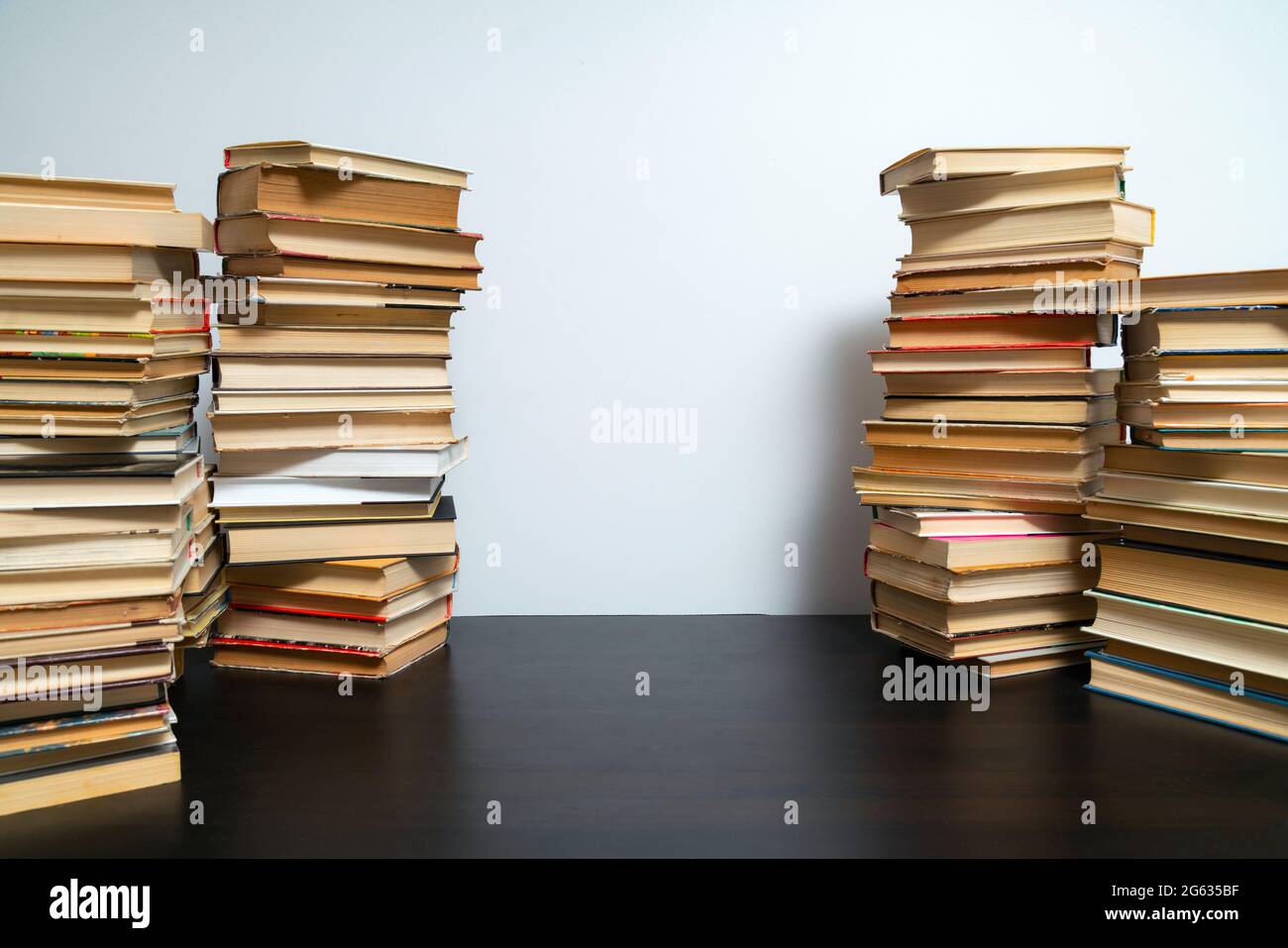 Grande pila di libri sul tavolo. Studiare prima dell'esame. Pila di libri d'epoca. Concetto di istruzione e di studio Foto Stock