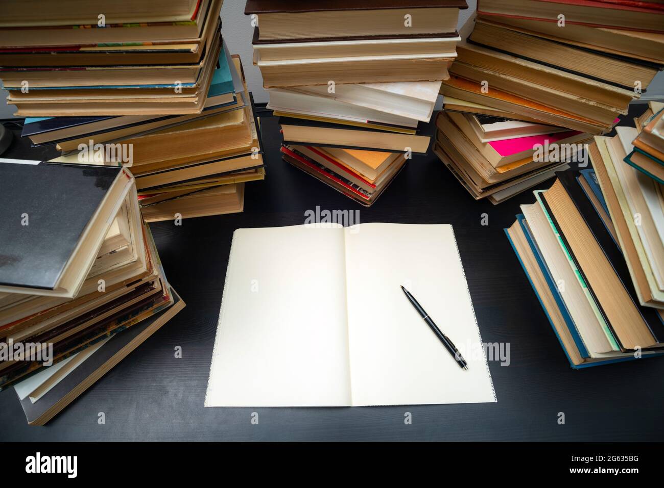 Grande pila di libri sul tavolo. Studiare prima dell'esame. Pila di libri d'epoca. Concetto di istruzione e di studio Foto Stock