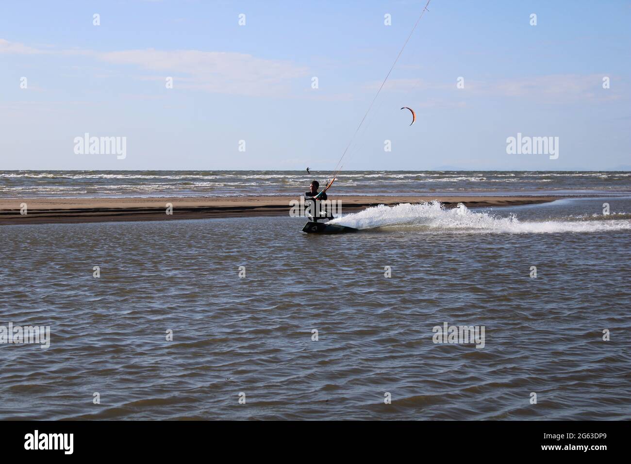 Vista sul mare con kiteboarder in lontananza, concetto di vacanza sportiva Foto Stock