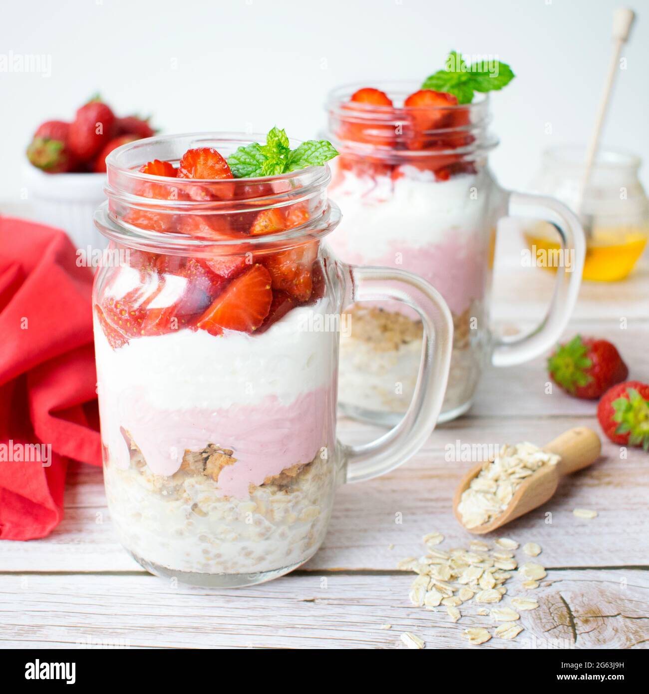 Una proposta di una sana colazione preparata a casa. Farinata d'avena con muesli, yogurt greco e fragole. Foto Stock