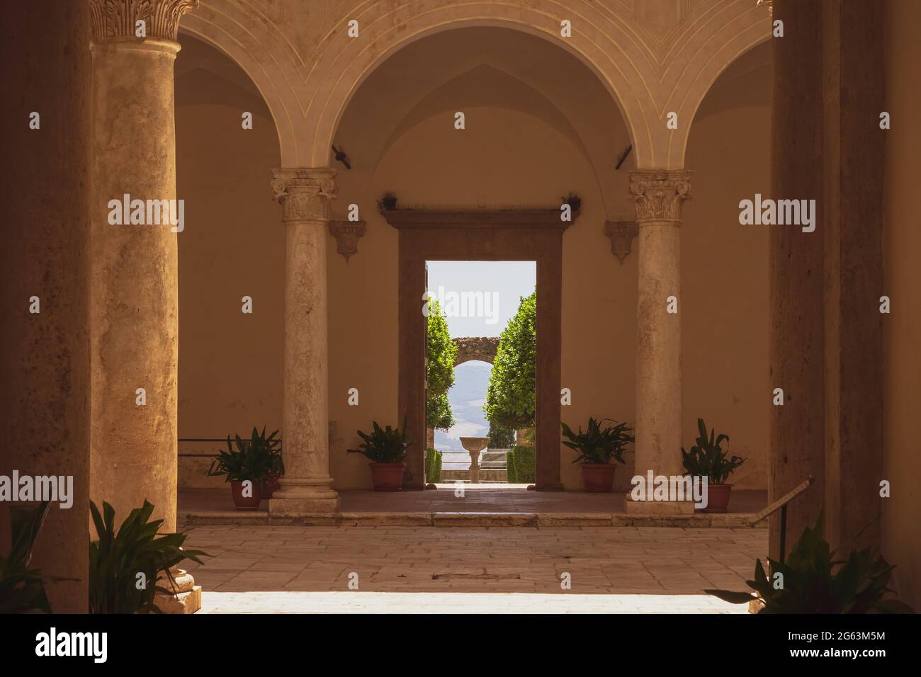 Vista sul bellissimo Chiostro di Palazzo Piccolomini nella famosa città di Pienza, Toscana, Italia. In lontananza la vista della campagna toscana Foto Stock