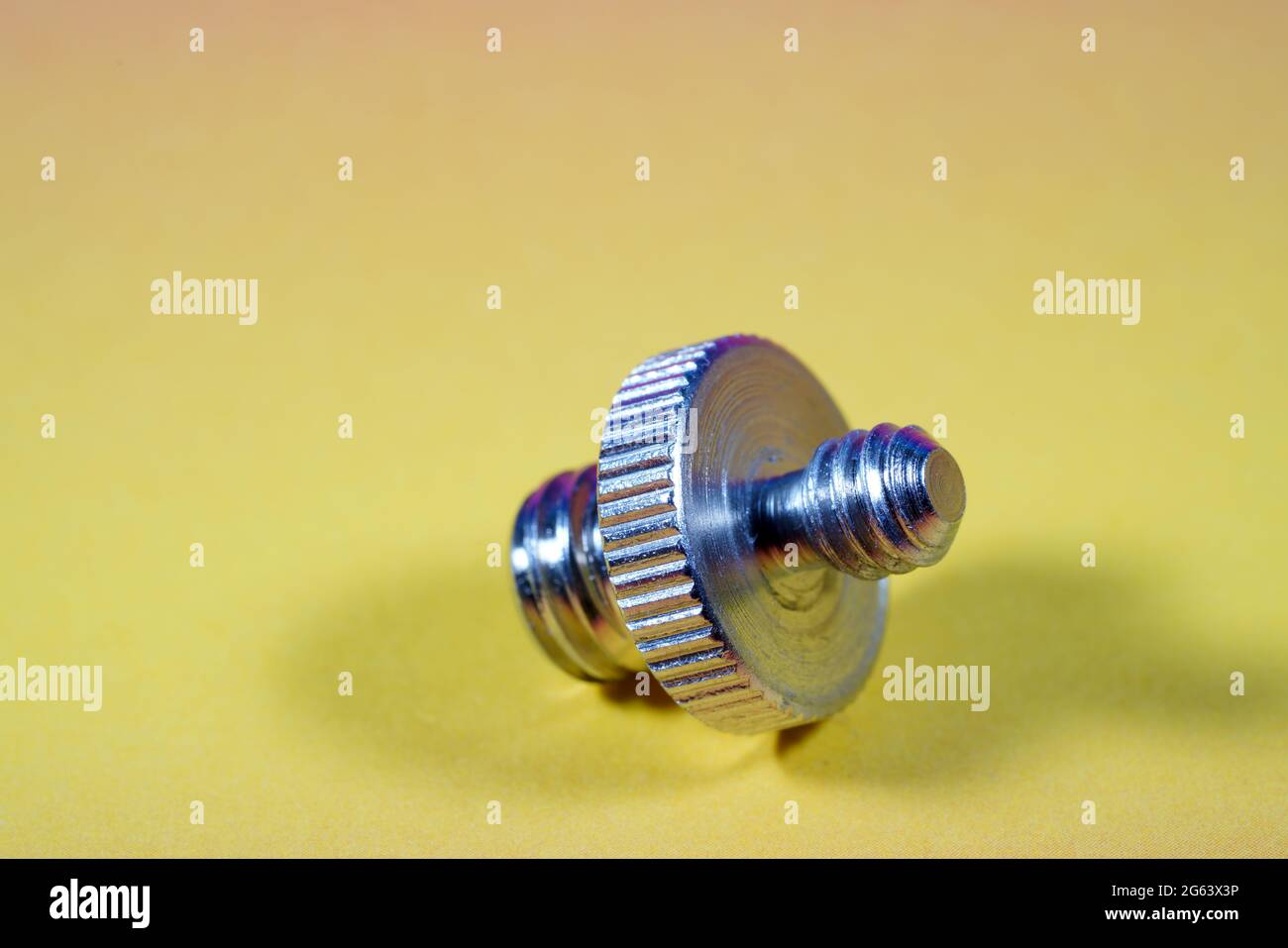 Adattatore per accessori fotografici da 4' a 3/4' su sfondo giallo Foto Stock