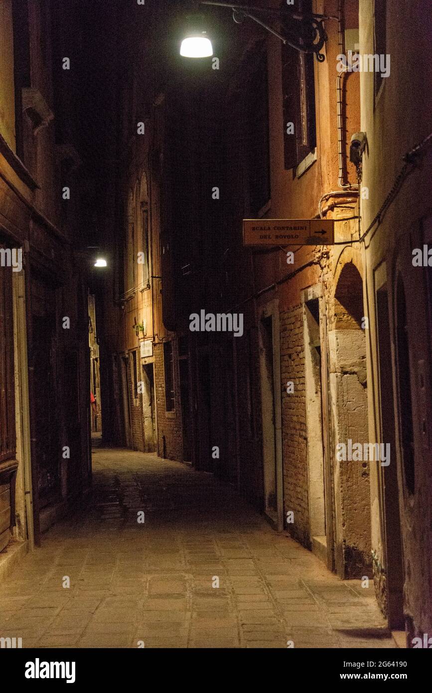 Una stradina poco illuminata a Venezia, in Italia Foto Stock