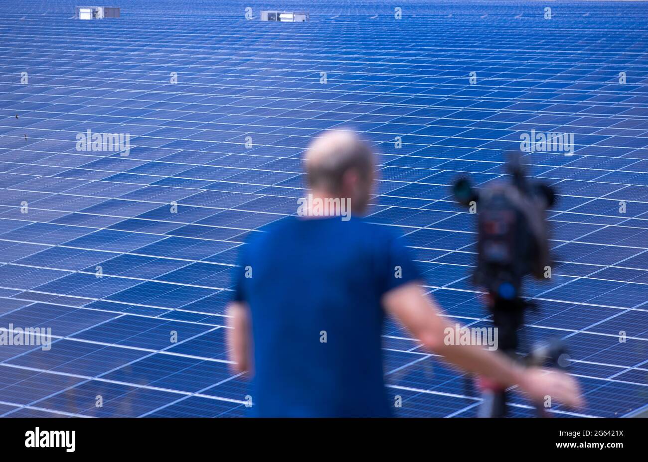 Zietlitz, Germania. 02 luglio 2021. Un cameraman filma quello che, secondo l'operatore, è il più potente parco solare del Meclemburgo-Vorpommern prima di essere ufficialmente collegato alla rete. Quasi 200,000 moduli solari sono stati installati su 86 ettari in una ex fossa di ghiaia. Il co-investitore è il fornitore di energia con sede a Schwerin Wemag. Il parco ha una produzione nominale di 80 megawatt e potrebbe generare circa 74,000 megawatt ore di elettricità all'anno, fornendo fino a 18,500 famiglie a quattro persone di energia. Credit: dpa Picture Alliance/Alamy Live News Foto Stock