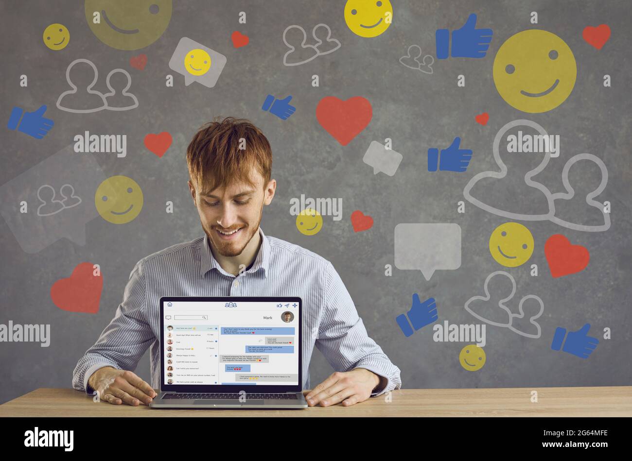 Happy Young guy mostra la versione desktop della nuova applicazione Messenger sullo schermo del computer portatile Foto Stock