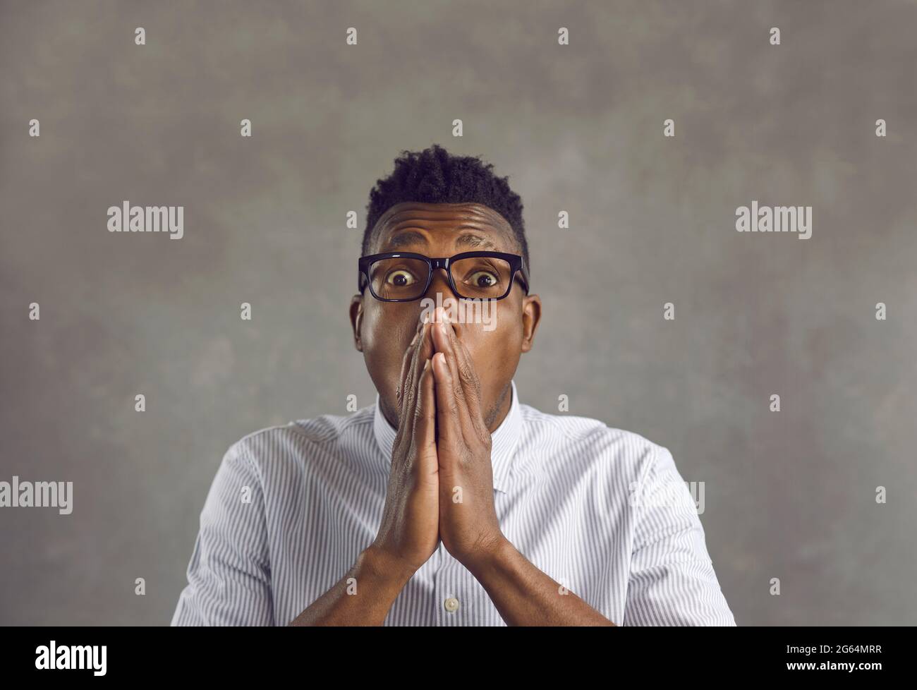 Temuto l'uomo afro-americano che copre la bocca con le mani si sente inorridito Foto Stock
