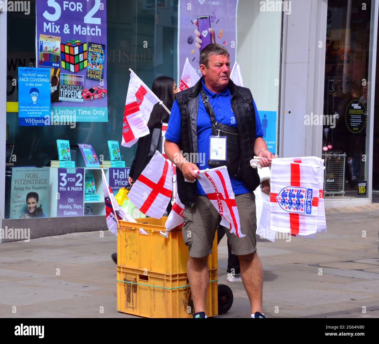 Uomo con carrello che vende bandiere d'Inghilterra nel centro di Manchester, Inghilterra, Regno Unito, 2 luglio 2021, Prima della partita di calcio Inghilterra / Ucraina il 3 luglio. Foto Stock