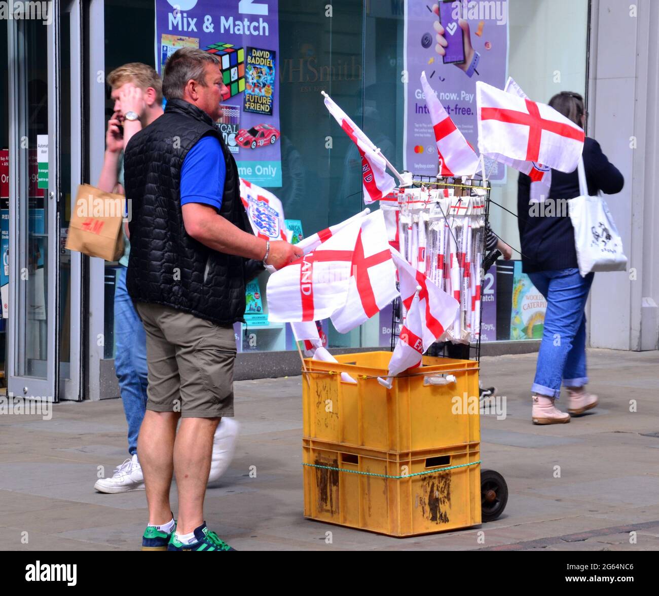 Uomo con carrello che vende bandiere d'Inghilterra nel centro di Manchester, Inghilterra, Regno Unito, 2 luglio 2021, Prima della partita di calcio Inghilterra / Ucraina il 3 luglio. Foto Stock