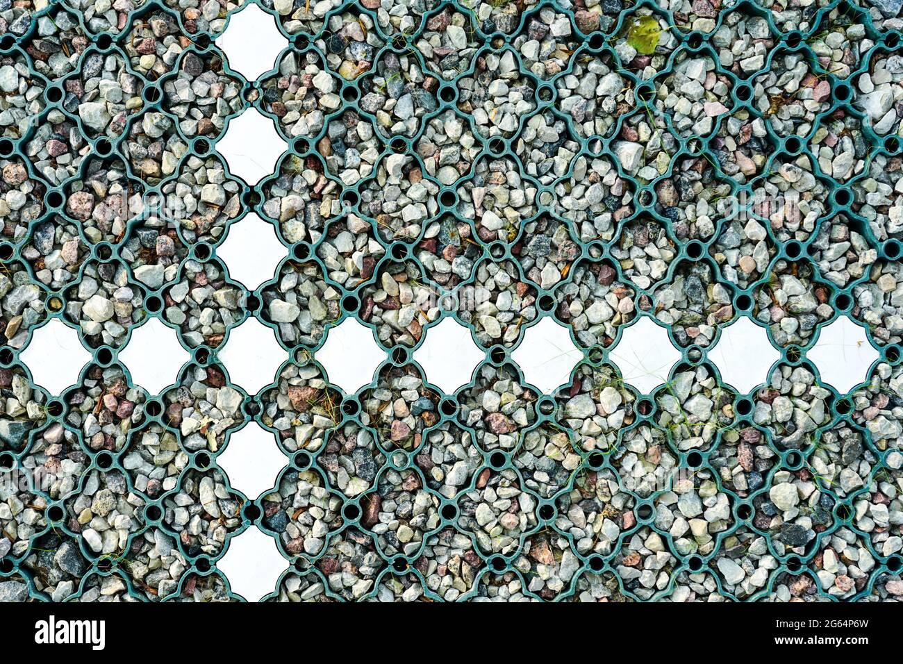 nuova base in ghiaia per parcheggi moderni con griglia in plastica verde e linee in plastica bianca installate Foto Stock