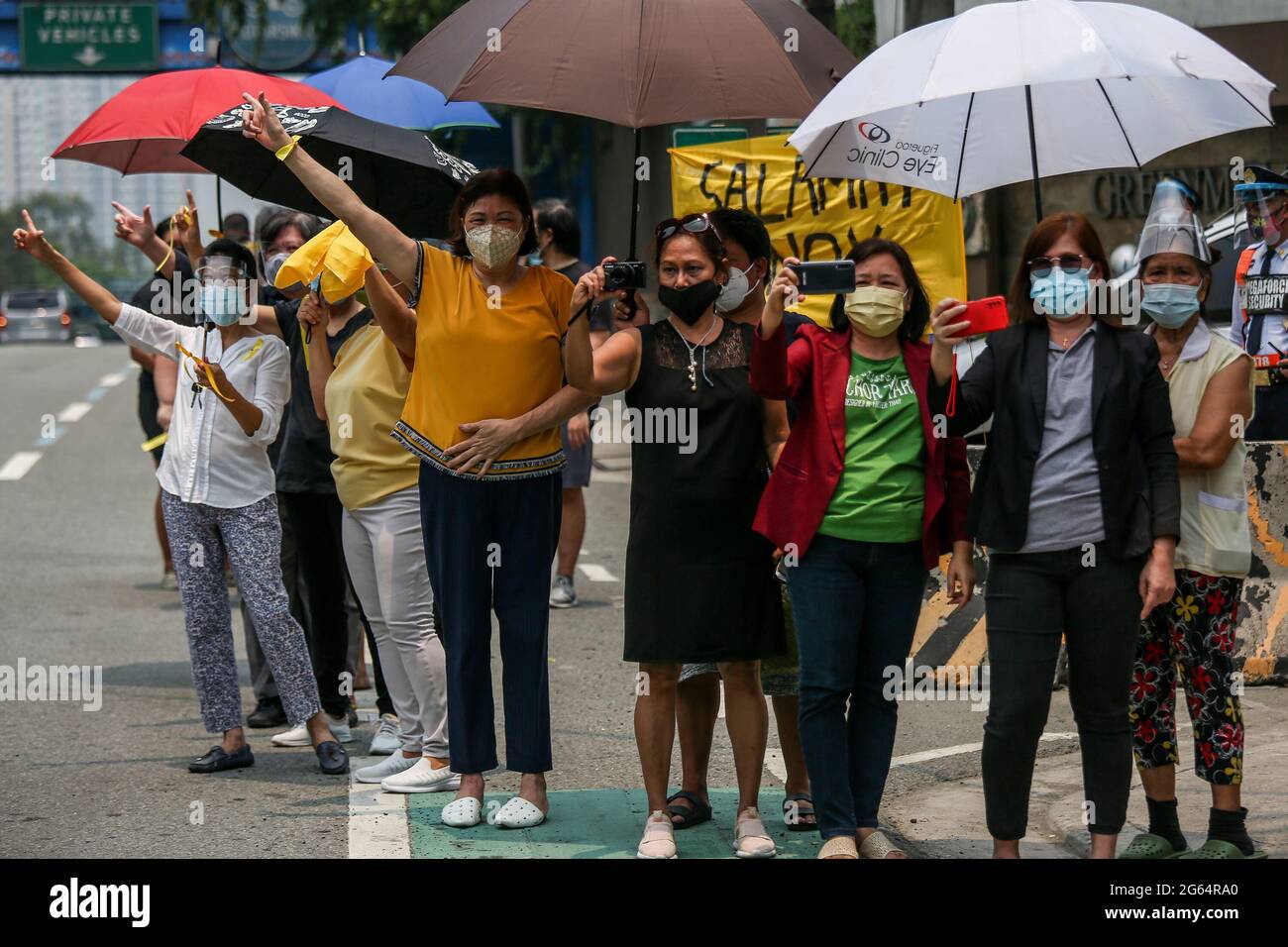 I sostenitori dell'ex presidente filippino Benigno Aquino III lampeggiano il segno 'L' che significa 'lotta!' Durante un corteo prima della sua sepoltura a Quezon City, Filippine. Foto Stock