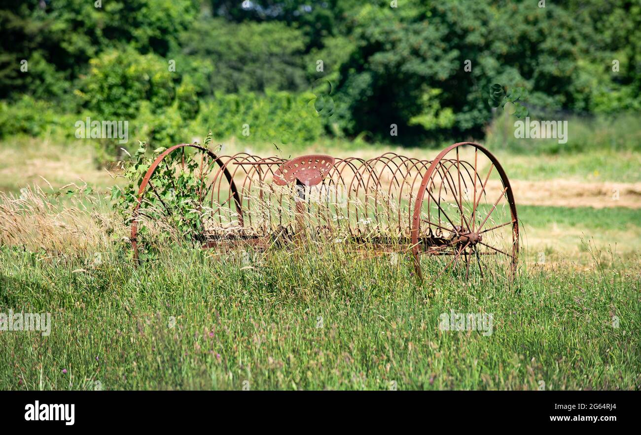 Un rastrello di fieno si ritirò in un campo in una fattoria a Dennis orientale, Massachusetts, Stati Uniti Foto Stock