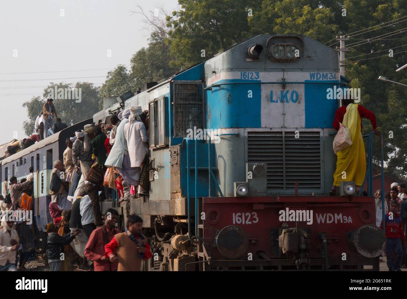 Treno indiano, con la gente appesa fuori esso Foto Stock