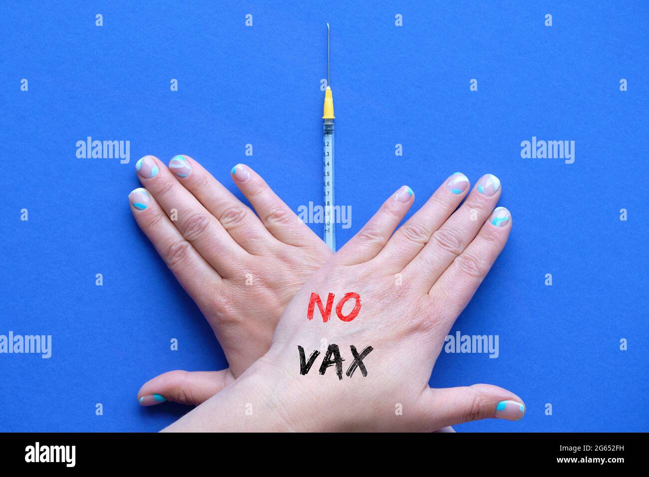 Concetto di rifiuto del vaccino. Mani incrociate con il testo No Vax Over vaccination syringe. Persona che rifiuta la vaccinazione dal morbillo, Covid-19. Anti-vaccinazione Foto Stock