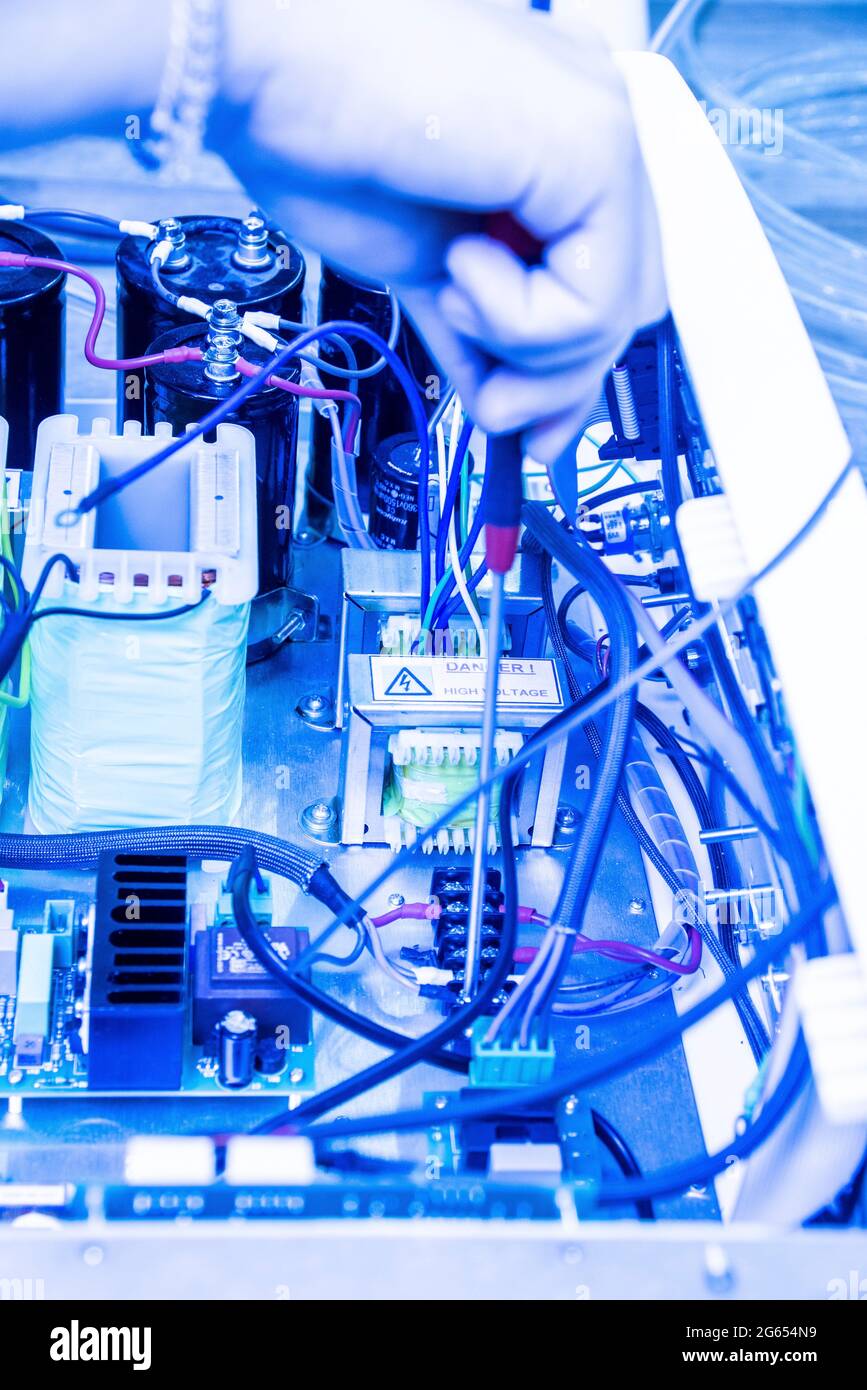 Tecnico che ripara un dispositivo elettronico Foto Stock