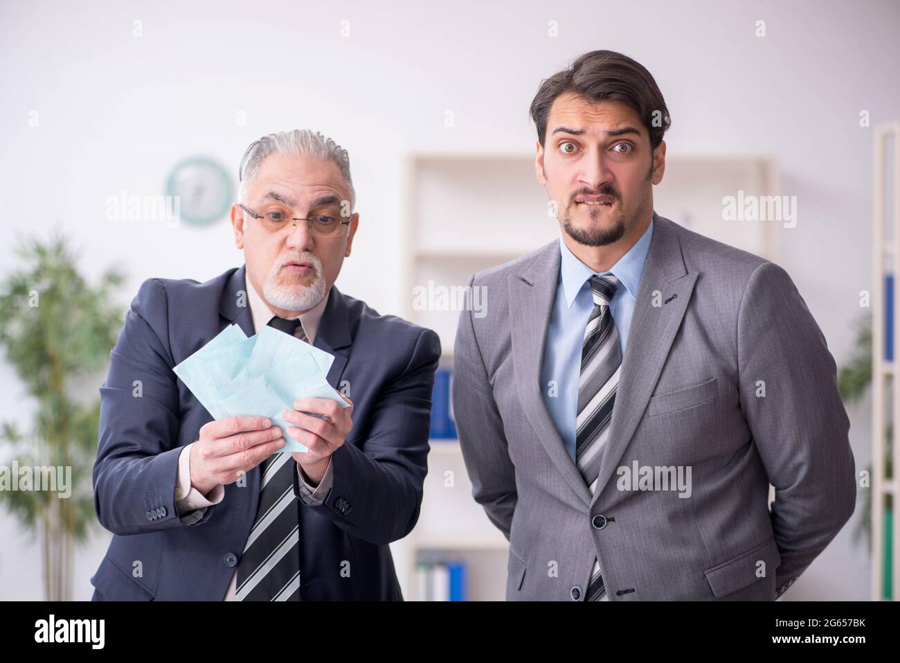 Due contabili maschi nel concetto di pianificazione del budget sul posto di lavoro Foto Stock