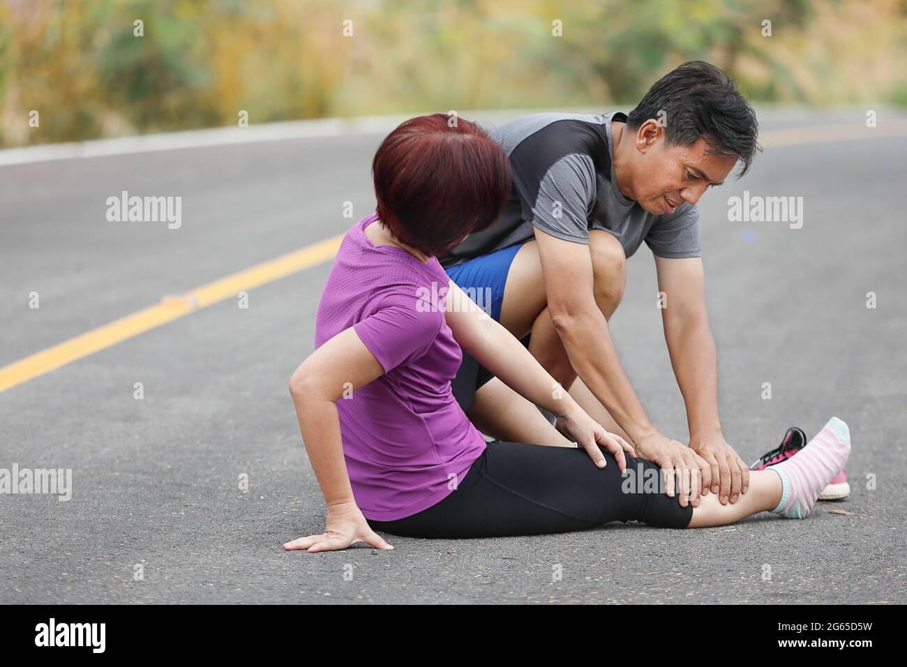 Femmina di mezza età con una cramp mentre jogging, massaggio vitello Foto Stock