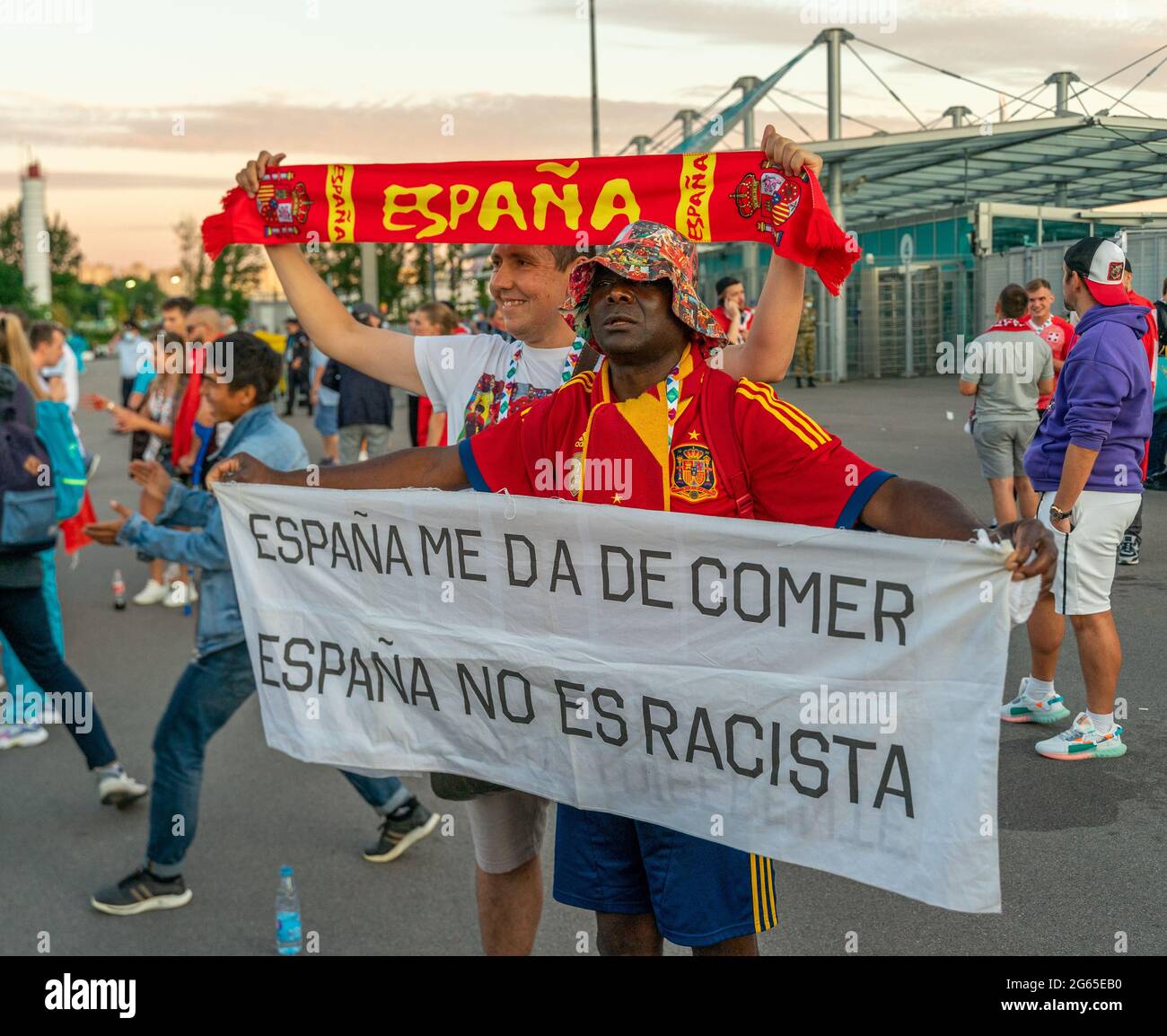 Tifoso spagnolo di calcio maschile nero vestito in abito nazionale, con bandiera 'Espana me da de comer, Espana no es racista', San Pietroburgo, Russia Foto Stock