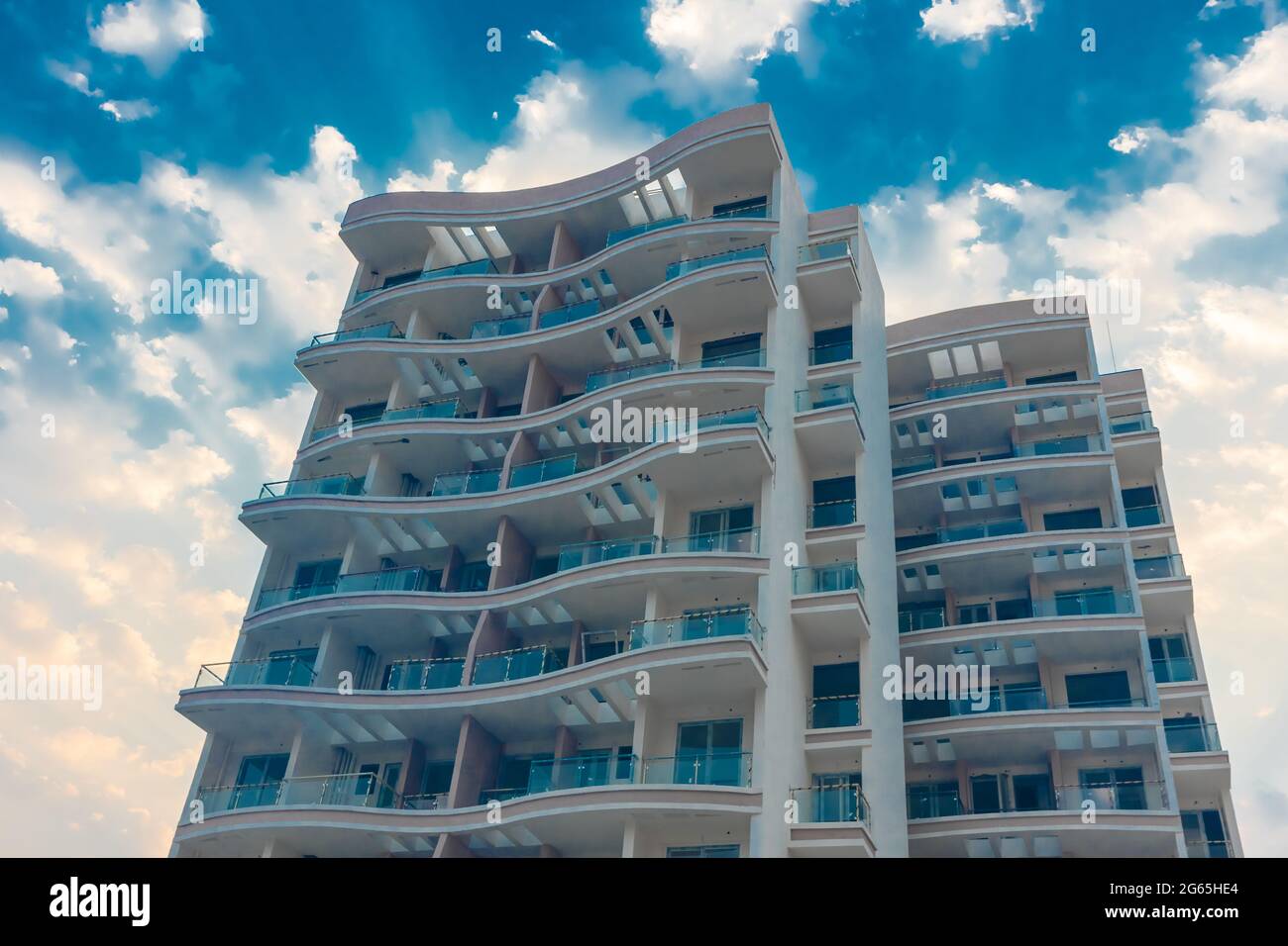 Uno sguardo ravvicinato di un edificio di nuova costruzione con nuvole e cielo blu sullo sfondo Foto Stock