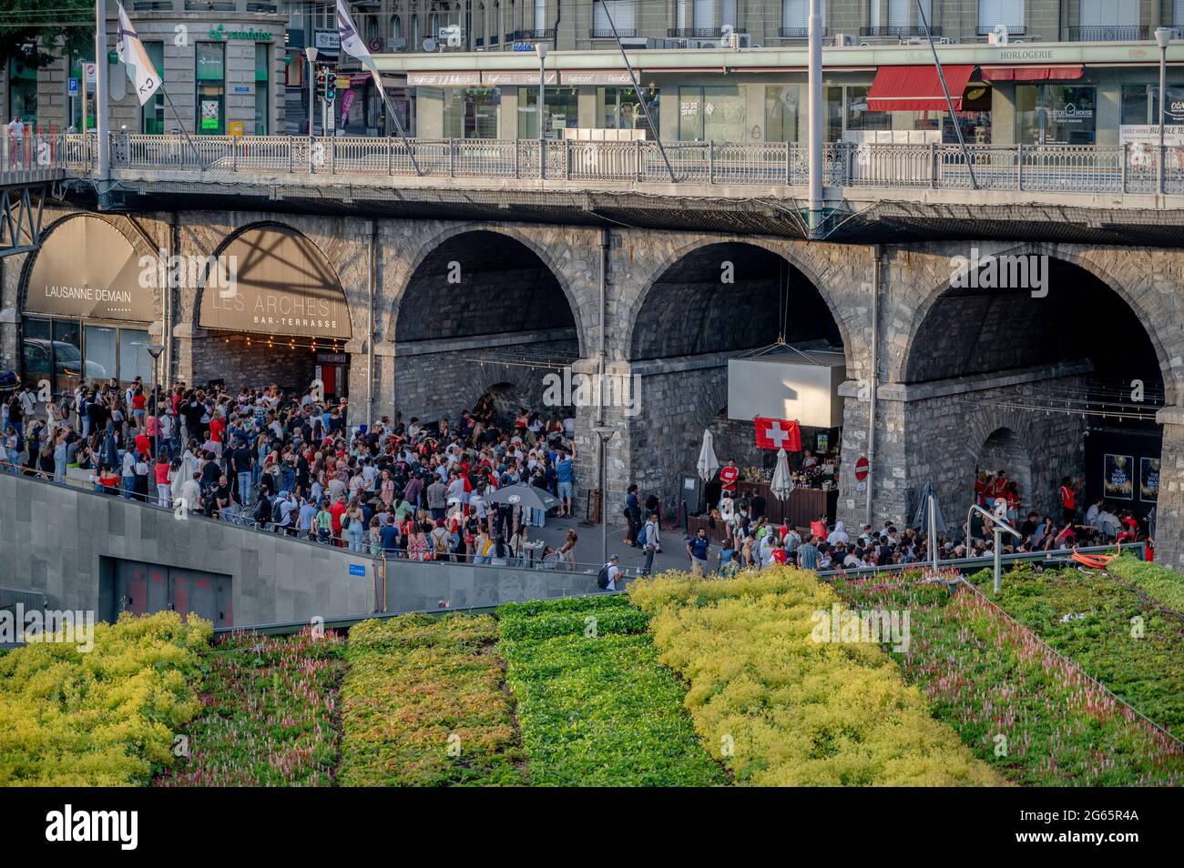 Losanna, Cantone di Vaud, Svizzera - 2 luglio 2021: Folla di persone che guardano la partita di calcio UEFA EURO 2020 Svizzera contro Spagna al bar all'aperto Foto Stock