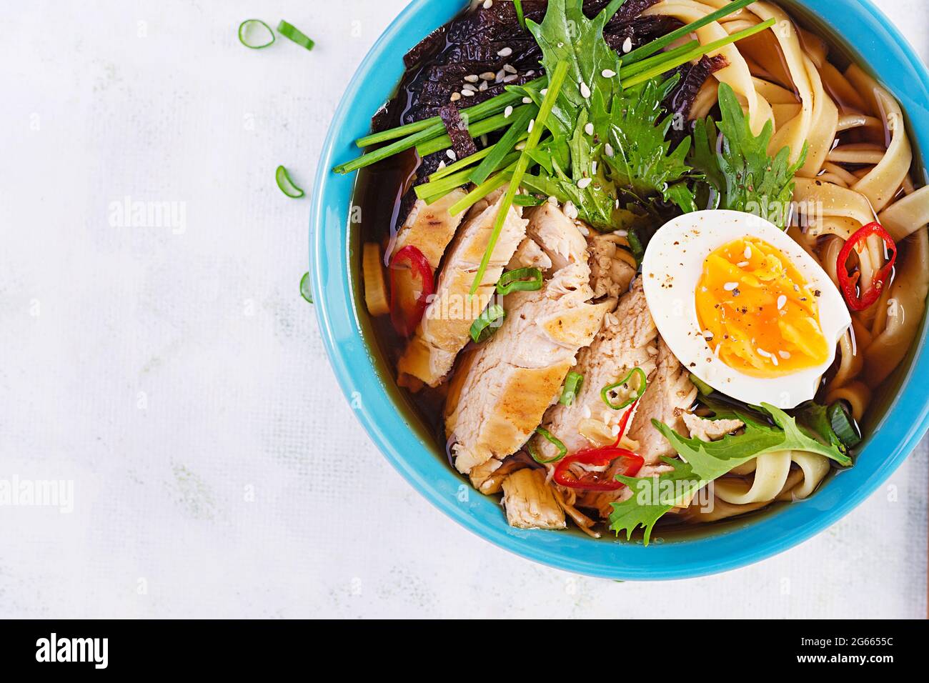 Zuppa di miso. Zuppa giapponese di ramen con pollo, uovo, nori e nippposinica su sfondo chiaro. Vista dall'alto, disposizione piatta Foto Stock