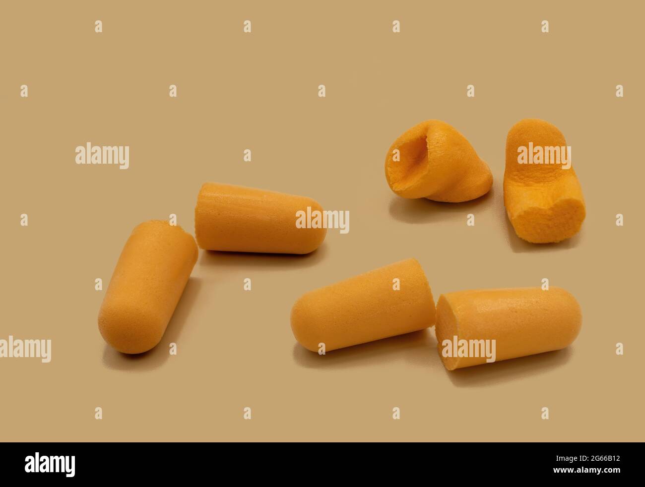 Tappi auricolari in schiuma di colore arancione per evitare rumori ambientali su sfondo arancione Foto Stock