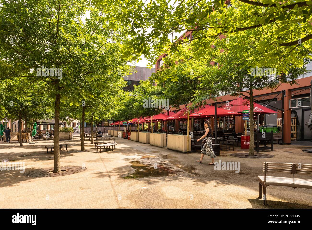 Eindhoven, Paesi Bassi 18 giugno 2021. Piazza nel centro della città con un ristorante Happy Italy, panchine, una ragazza a piedi e un sacco di alberi e di verde Foto Stock