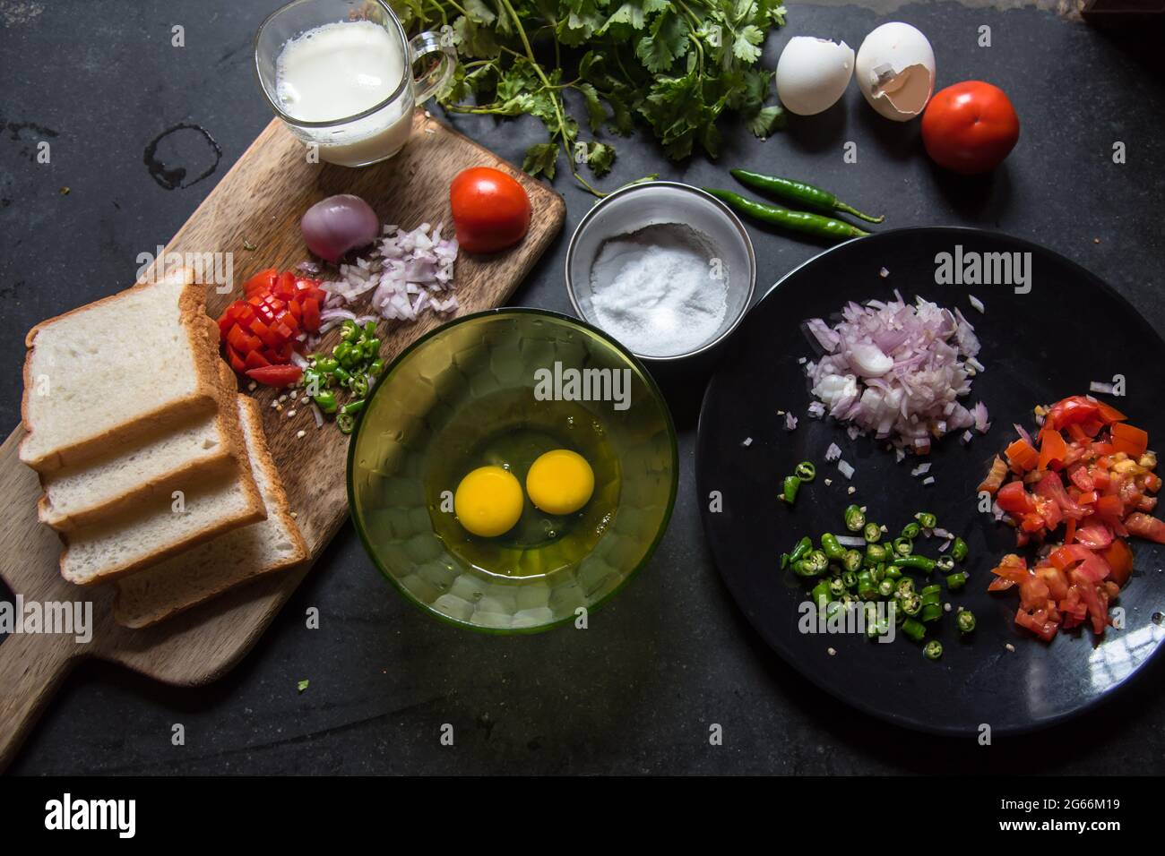 Prima colazione ingredienti uova, fette di pane, verdure tritate su uno sfondo con l'uso di fuoco selettivo Foto Stock