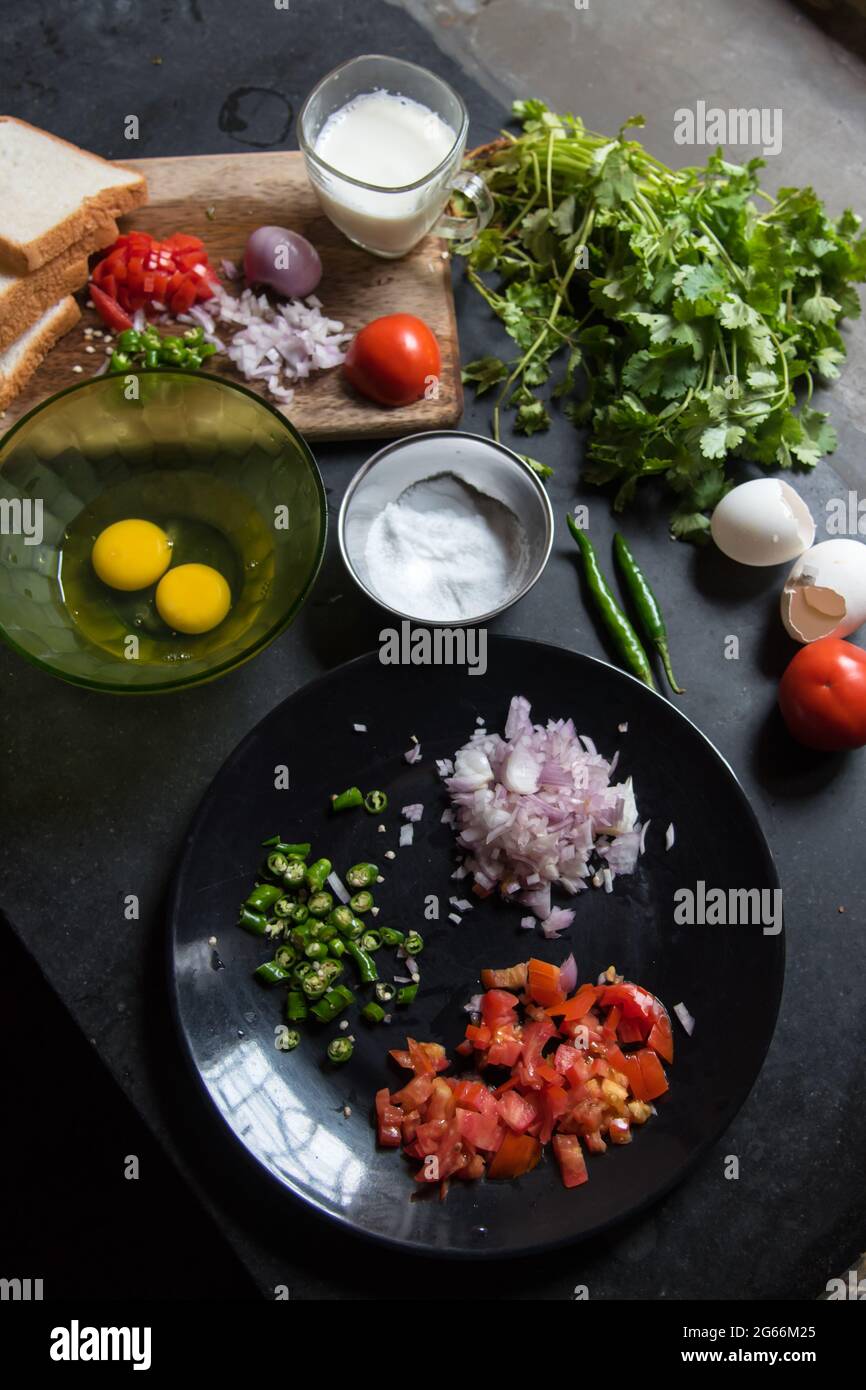 Ingredienti vegetali tritati cipolla, pomodoro e peperoncino verde su un piatto con uso di fuoco selettivo Foto Stock