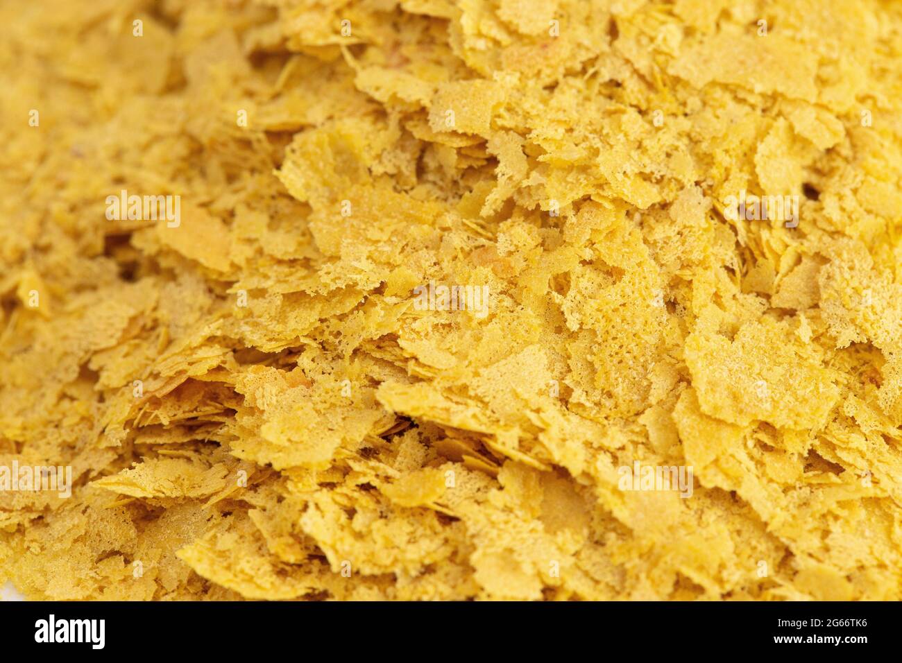 Le scaglie di colore giallo di lievito nutrizionale di un sostituto di formaggio e condimenti per la cucina vegana Foto Stock