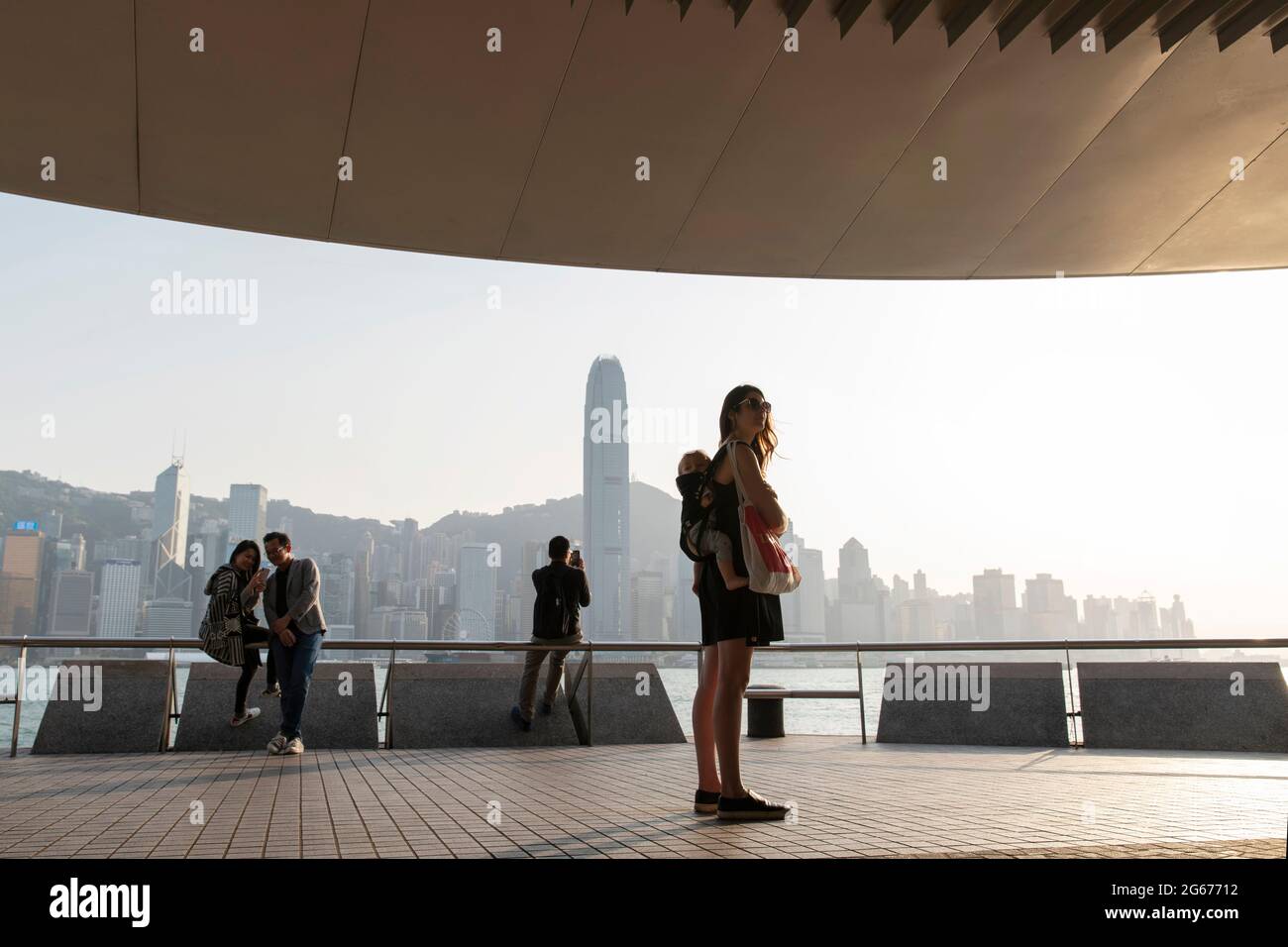 Una madre e un bambino che camminano intorno al porto di Hong Kong, lato Tsim Sha Tsui Foto Stock