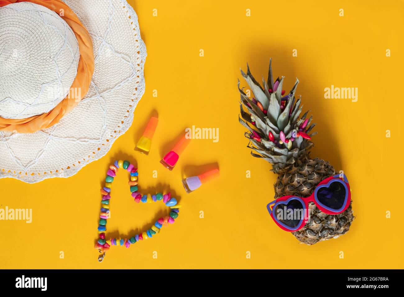 Composizione estiva. Ananas in occhiali da sole, cappello, perline e unghie  lucidare su uno sfondo giallo con spazio di copia. Concetto di vacanza.  Vista dall'alto, disposizione piatta Foto stock - Alamy