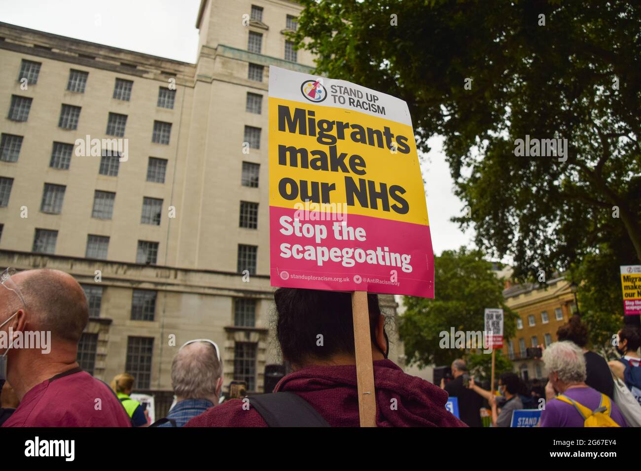 Londra, Regno Unito. 3 luglio 2021. Un protester tiene un cartello 'i migranti fanno il nostro NHS' fuori Downing Street. I lavoratori e i sostenitori del NHS (National Health Service) hanno marciato attraverso il centro di Londra chiedendo un equo aumento salariale per il personale del NHS e in generale il sostegno del NHS. (Credit: Vuk Valcic / Alamy Live News) Foto Stock