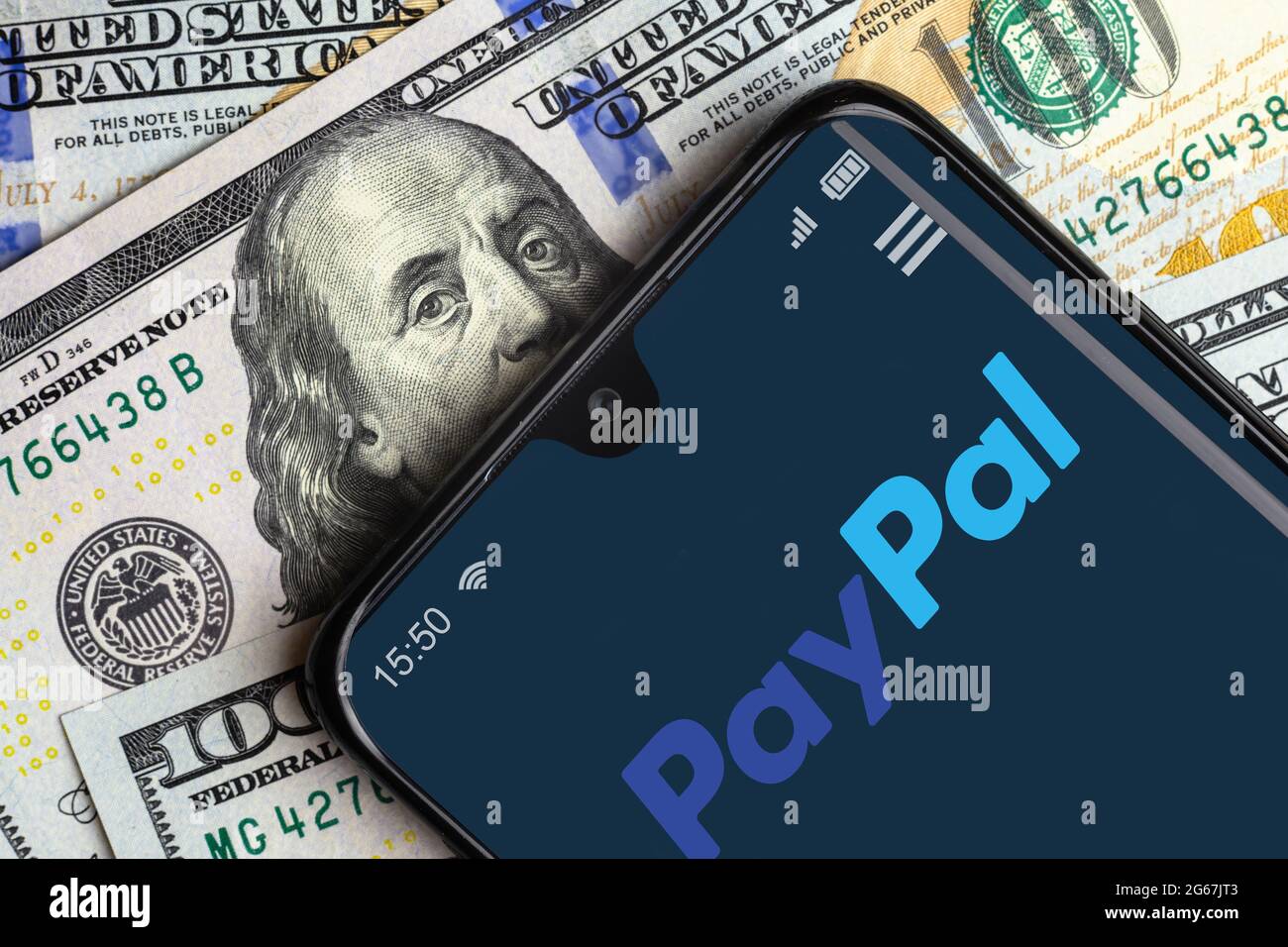 Mosca - 10 giugno 2021: Logo PayPal sullo schermo dello smartphone e bollette in dollari, app digitale per il pagamento nel telefono cellulare. Concetto di denaro virtuale, paypal s. Foto Stock